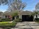 Charming single-story home featuring a well-manicured lawn, lush landscaping, and inviting screened-in porch at 3812 Westerham Dr, Clermont, FL 34711