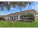 Spacious backyard with a patio set, a swing, and vibrant landscaping at 4034 River Crest Cir, Leesburg, FL 34748
