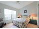 Bedroom featuring a floral comforter, a window with blinds, and neutral carpeted floors at 4034 River Crest Cir, Leesburg, FL 34748
