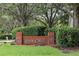 Charming brick community sign for River Crest under a canopy of mature trees and lush landscaping at 4034 River Crest Cir, Leesburg, FL 34748