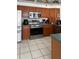 Well-lit kitchen featuring stainless steel appliances, wood cabinets, and a neutral backsplash at 4034 River Crest Cir, Leesburg, FL 34748