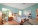 Bright main bedroom featuring a ceiling fan, windows, light blue walls, and carpet floors at 4034 River Crest Cir, Leesburg, FL 34748