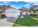 Single-story house with white exterior, attached garage, and well-manicured lawn at 509 Baytree Blvd, Tavares, FL 32778