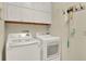 Well-lit laundry room featuring a white washer and dryer with overhead cabinets for extra storage space at 509 Baytree Blvd, Tavares, FL 32778