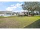 Expansive backyard with lush green grass, landscaping and brick retaining walls at 5095 China Sea Dr, Tavares, FL 32778