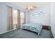 Bedroom featuring blue walls, carpet, ceiling fan, and bright windows overlooking the outdoor landscaping at 5095 China Sea Dr, Tavares, FL 32778