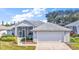 Well-kept single-story home with a screened-in porch and attached garage, showcasing its tidy landscaping at 5095 China Sea Dr, Tavares, FL 32778