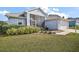 Single-story home features a screened porch and attached garage, surrounded by landscaped grounds and lush lawn at 5095 China Sea Dr, Tavares, FL 32778