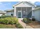 Charming home featuring a screened-in porch, manicured landscaping, and a neatly paved walkway to the front door at 5095 China Sea Dr, Tavares, FL 32778