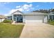 Inviting single-story home featuring a screened front porch, attached garage, and a well-maintained front lawn at 5095 China Sea Dr, Tavares, FL 32778