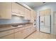 Kitchen featuring tile floors, modern gas cooktop, wall ovens, lots of cabinet space, and a white refrigerator at 5095 China Sea Dr, Tavares, FL 32778