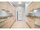 Traditional kitchen featuring tile flooring, tan cabinets, and a suite of white appliances at 5095 China Sea Dr, Tavares, FL 32778