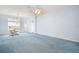Open-concept living room featuring carpet, large windows, and a ceiling fan at 5095 China Sea Dr, Tavares, FL 32778