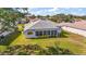 Back exterior showing a single-story home with a screened-in lanai, and a well-maintained lawn on a sunny day at 5095 China Sea Dr, Tavares, FL 32778