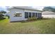 Back of the home featuring a sun room with many windows overlooking the lawn at 5095 China Sea Dr, Tavares, FL 32778