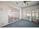 This enclosed sunroom features carpeted floors, neutral colors, and sliding glass doors leading to the outdoors at 5095 China Sea Dr, Tavares, FL 32778