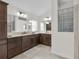Bathroom boasts double sinks with dark wood cabinetry, tile flooring and glass block window at 5819 White Ibis, The Villages, FL 32163