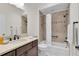 Bathroom with vanity, toilet and tub-shower featuring a tile surround and bronze fixtures at 5819 White Ibis, The Villages, FL 32163