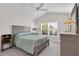 This bedroom features a ceiling fan, neutral walls, and a large window at 5819 White Ibis, The Villages, FL 32163