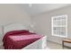 This bedroom has a bed with a red comforter, a ceiling fan and a window at 5819 White Ibis, The Villages, FL 32163
