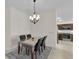 Traditional dining room with dark wood table and seating, plus modern chandelier and access to kitchen at 5819 White Ibis, The Villages, FL 32163