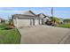 A wide driveway leads to a well maintained home, complemented by tropical landscaping, and two-car garage at 5819 White Ibis, The Villages, FL 32163