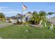 Inviting single-story home with lush landscaping, a spacious two-car garage, and an American flag displayed at 5819 White Ibis, The Villages, FL 32163