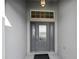 Elegant front door with decorative glass accents and a transom window, enhancing curb appeal and natural light at 5819 White Ibis, The Villages, FL 32163