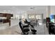 Open-concept living area featuring comfortable seating, neutral tones, large windows, and seamless flow to the outdoors at 5819 White Ibis, The Villages, FL 32163