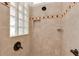 Walk-in shower with light tile, bronze fixtures and a glass block window at 5819 White Ibis, The Villages, FL 32163