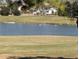 A scenic view of a pond populated with birds, complemented by the surrounding green landscape at 589 Plaintain Path, The Villages, FL 32162