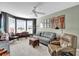 Comfortable living room with a bay window, neutral carpet, and a ceiling fan at 589 Plaintain Path, The Villages, FL 32162