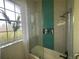 Well-lit bathroom featuring a glass shower with a blue accent tile and a large window at 5910 Lake Emma Ct, Groveland, FL 34736