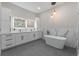 Elegant bathroom with dual sinks, marble countertops, a soaking tub, and modern fixtures for a spa-like experience at 5910 Lake Emma Ct, Groveland, FL 34736