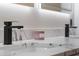 Close-up of a bathroom vanity featuring sleek black faucets and marble countertops adding elegance to this space at 5910 Lake Emma Ct, Groveland, FL 34736