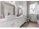 Bathroom with double vanity, white cabinets, and large mirrors at 5910 Lake Emma Ct, Groveland, FL 34736