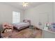 Charming bedroom with a pink bed, chair, and colorful rug at 5910 Lake Emma Ct, Groveland, FL 34736