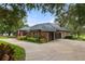 Charming brick home features a manicured lawn and a circular driveway at 5910 Lake Emma Ct, Groveland, FL 34736