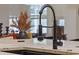 Close-up of a modern black gooseneck kitchen faucet with marble countertop at 5910 Lake Emma Ct, Groveland, FL 34736