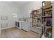 Bright laundry room with washer, dryer, utility sink, and ample storage shelving at 5910 Lake Emma Ct, Groveland, FL 34736