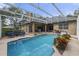 Enclosed pool area offers a relaxing retreat, featuring a pool, spa, and outdoor seating under a screened enclosure at 5910 Lake Emma Ct, Groveland, FL 34736