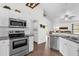 Modern kitchen with stainless steel appliances, white cabinetry, and an open layout leading to other areas of the house at 7191 Hemlock Loop, Ocala, FL 34472