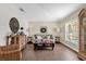 Cozy living room with neutral tones, stylish decor, and a large window providing natural light and wood-look flooring at 7191 Hemlock Loop, Ocala, FL 34472