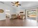 Relaxing living room with comfortable seating, ceiling fan, and a sliding glass door to the patio at 7191 Hemlock Loop, Ocala, FL 34472