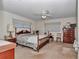 Comfortable bedroom featuring a four-poster bed, a ceiling fan, and neutral carpeting at 8862 Sw 92Nd St # D, Ocala, FL 34481