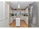 Efficient kitchen with white cabinets, stainless steel refrigerator, a small island, and modern appliances at 8862 Sw 92Nd St # D, Ocala, FL 34481