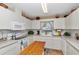 Bright kitchen featuring white cabinetry, neutral countertops, a window with blinds, and stainless steel appliances at 8862 Sw 92Nd St # D, Ocala, FL 34481