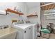 Functional laundry room with modern washer and dryer, overhead shelving and utility sink at 8862 Sw 92Nd St # D, Ocala, FL 34481
