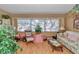 Comfortable living room filled with plants, a large window, and a sitting area, creating a warm and inviting ambiance at 8862 Sw 92Nd St # D, Ocala, FL 34481