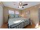Bright bedroom with wood floors, light blue bedding, ceiling fan, and wood paneled walls at 920 Morningview Dr, Tavares, FL 32778